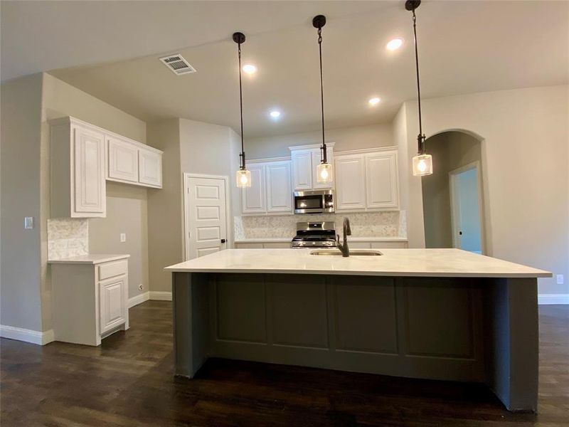Kitchen island is highlighted by ORB pendant lights as a focal point Kitchen island is highlighted by ORB pendant lights as a focal point