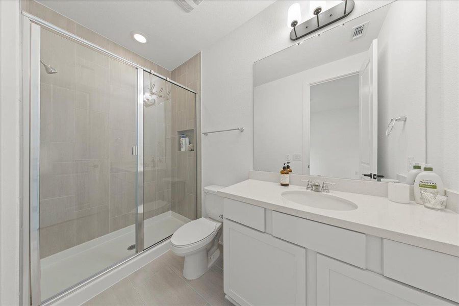 Bathroom featuring a shower stall, light tile patterned floors, vanity, and recessed lighting Bathroom featuring a shower stall, light tile patterned floors, vanity, and recessed lighting