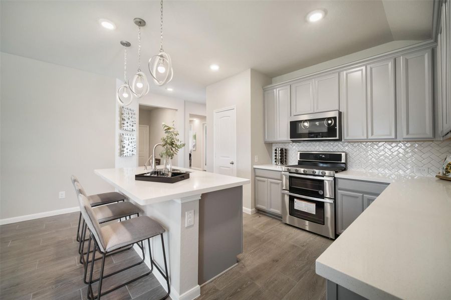 This kitchen is by far any chef’s dream! This spacious kitchen features high ceilings, light stained wood cabinets, granite countertop, SS appliances, modern tile backsplash, recessed lighting, extended counter space, granite kitchen island with double sink, and space for breakfast bar, and a walk-in pantry all overlooking your huge family room. Sample photo of completed home with similar floor plan. Actual colors and selections may vary.