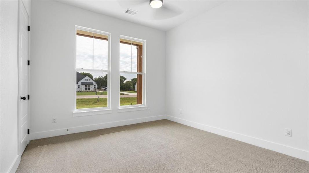 Empty room featuring ceiling fan and carpet floors