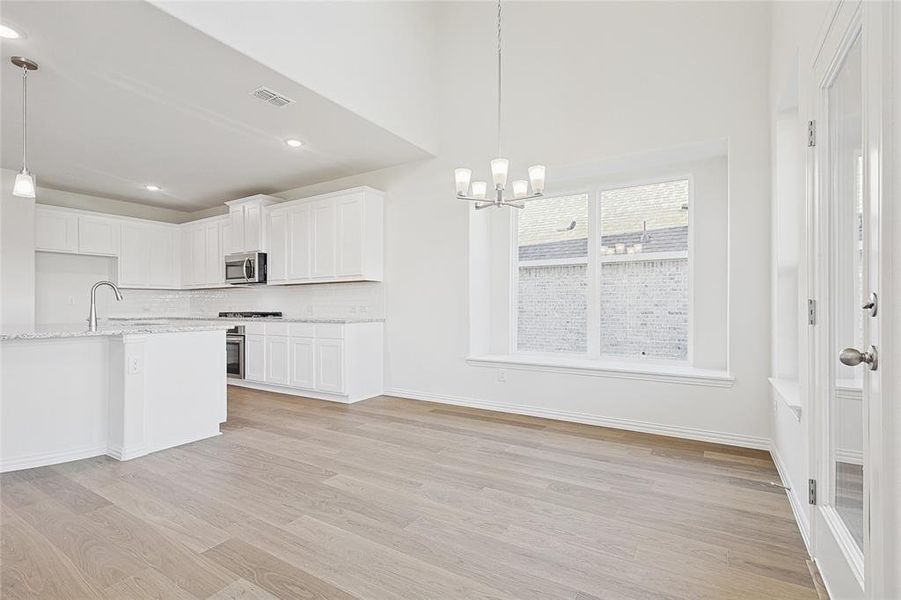 Kitchen featuring white cabinetry, light hardwood / wood-style flooring, and stainless steel appliances