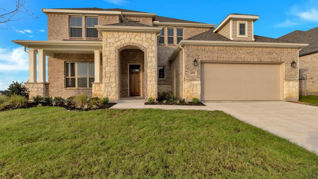 View of front of house featuring a front yard and a garage