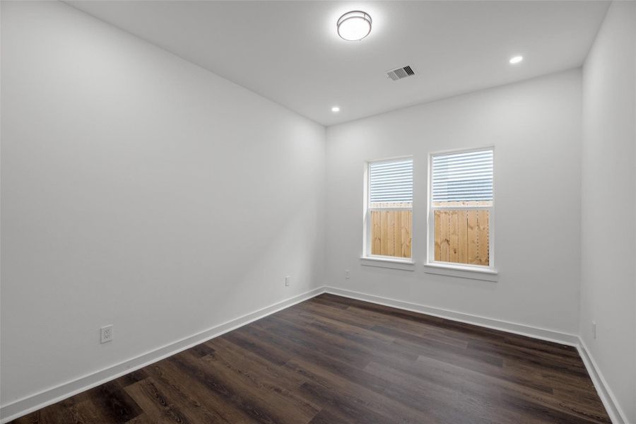 Vibrant, minimalist room with white walls, dark wood flooring, and two windows letting in natural light. Perfect for an office or small bedroom. Vibrant, minimalist room with white walls, dark wood flooring, and two windows letting in natural light. Perfect for an office or small bedroom.