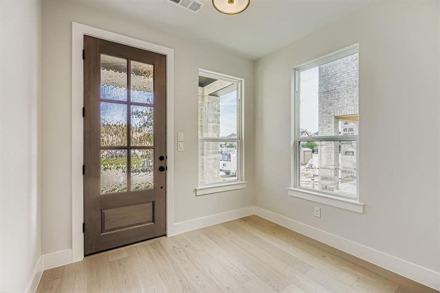 Entrance foyer with healthy amount of natural light and light wood-type flooring
