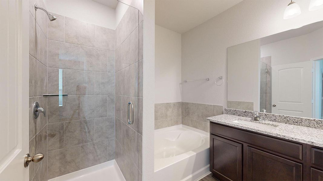 Bathroom featuring a bath, vanity, and a stall shower