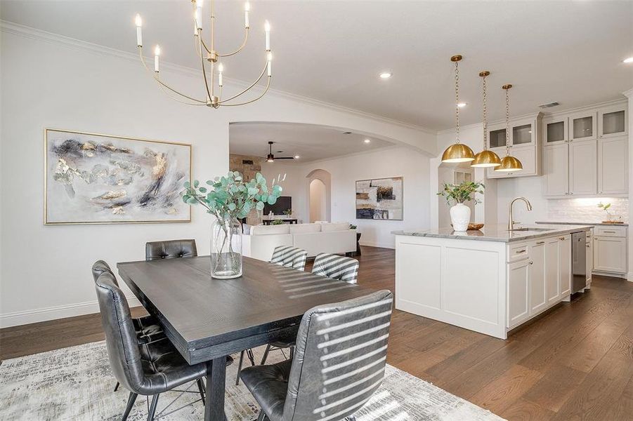 Dining space featuring chandelier, large windows to provide natural light, and crown molding