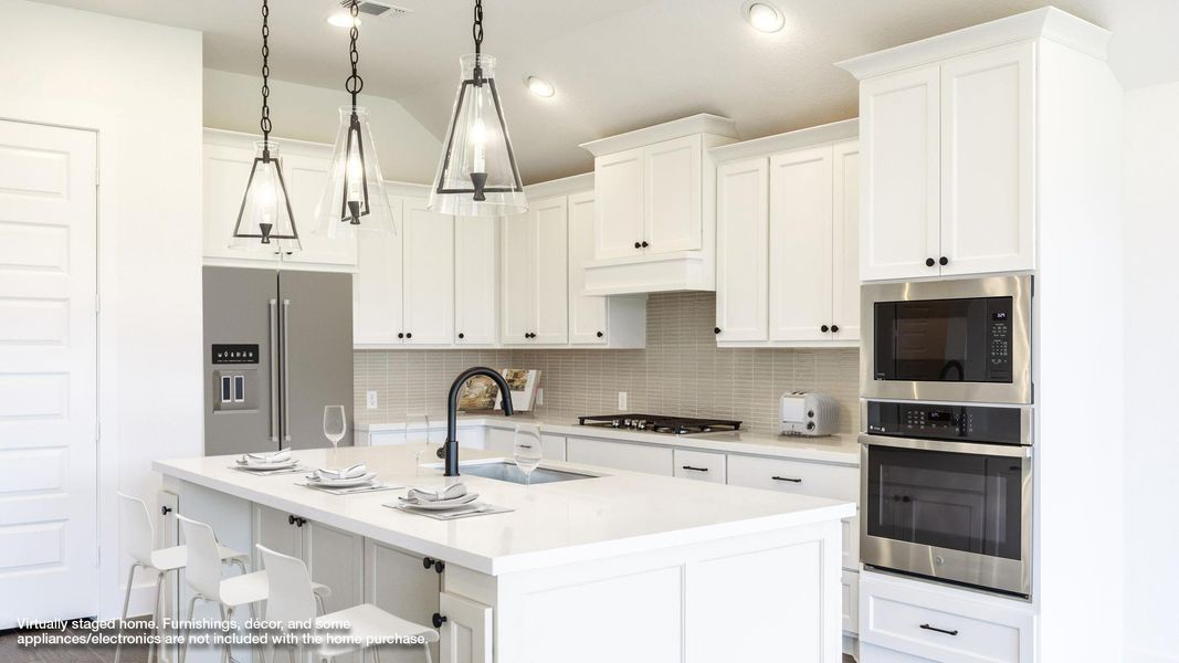 Kitchen with stainless steel appliances, tasteful backsplash, a breakfast bar area, light countertops, and white cabinetry