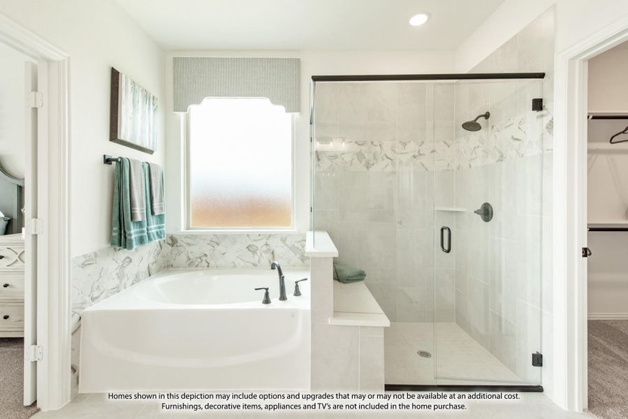 Master bathroom with soaking tub, glass-enclosed shower, marble tile surround, and walk-in closet entry
