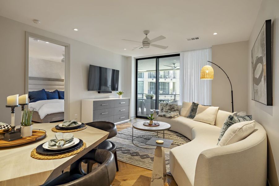 Hardwood floors and sliding glass doors enhance this elegant, open-concept living space with balcony access.
