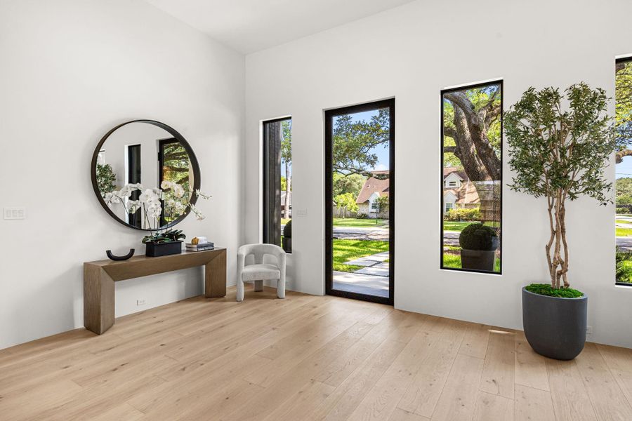 Guests are greeted by a contemporary steel & glass front entry door, 14 ft ceilings & engineered wood floors.