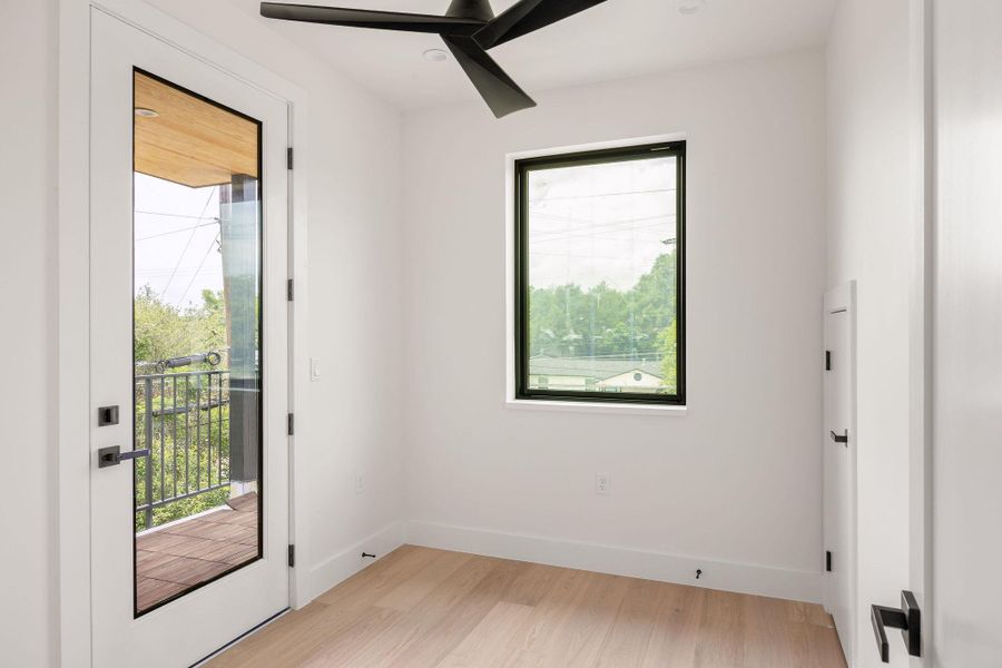 Spare room featuring healthy amount of natural light, light wood finished floors, and a ceiling fan Spare room featuring healthy amount of natural light, light wood finished floors, and a ceiling fan
