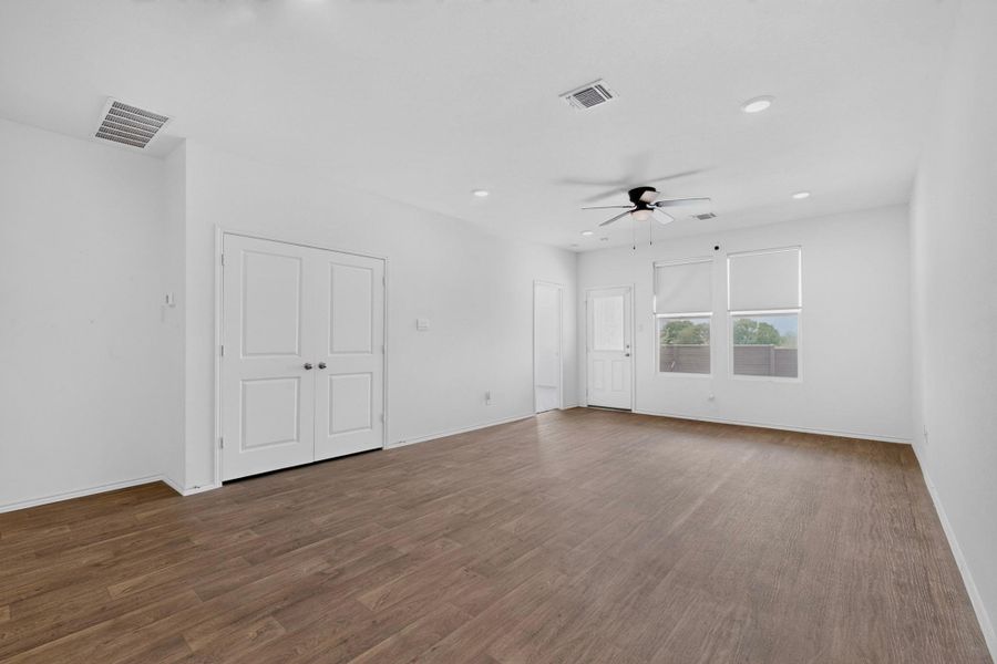 Rich wood flooring anchors this versatile space under smooth ceilings with integrated recessed lighting. Rich wood flooring anchors this versatile space under smooth ceilings with integrated recessed lighting.