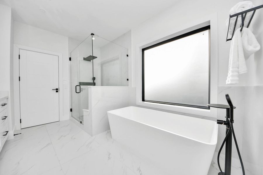 Notice the large freestanding tub thoughtfully placed by an expansive window.