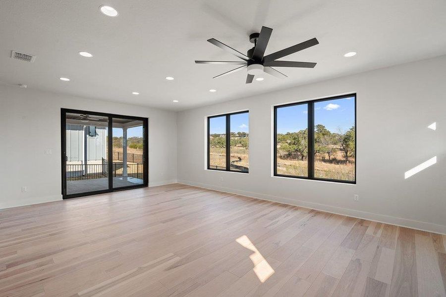 Empty room with a ceiling fan, light wood-type flooring, and recessed lighting