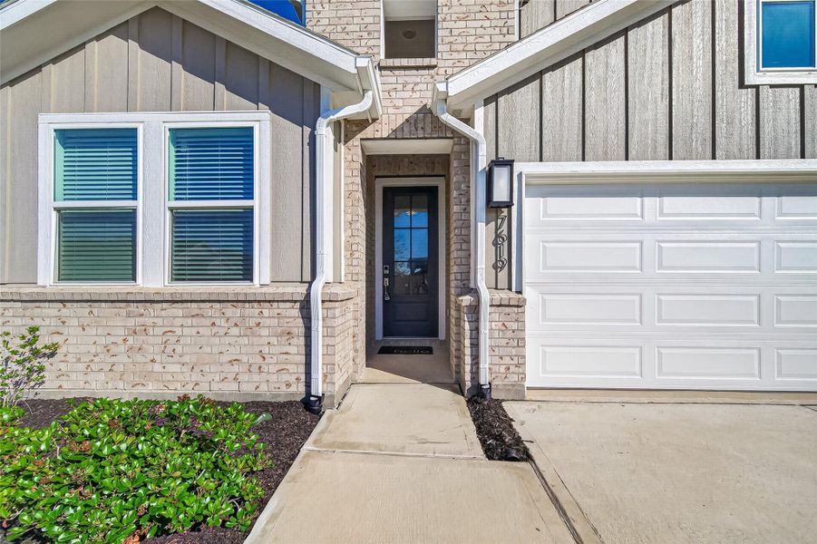 Welcoming covered front entry with contemporary exterior finishes and charming curb appeal.