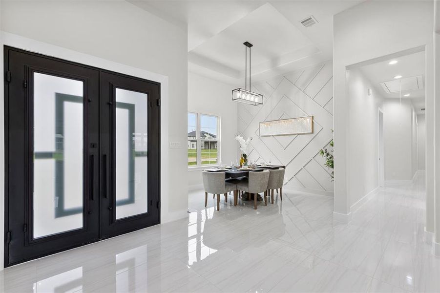 Foyer with tile, tray ceiling, and Iron doors.