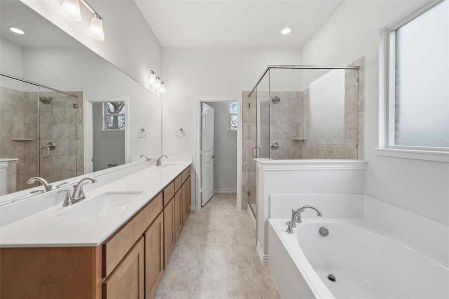 Full bathroom featuring double vanity, a bath, and a stall shower Full bathroom featuring double vanity, a bath, and a stall shower