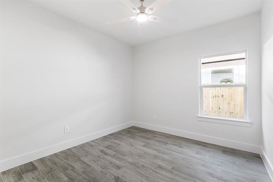 Empty room with light hardwood / wood-style floors and ceiling fan