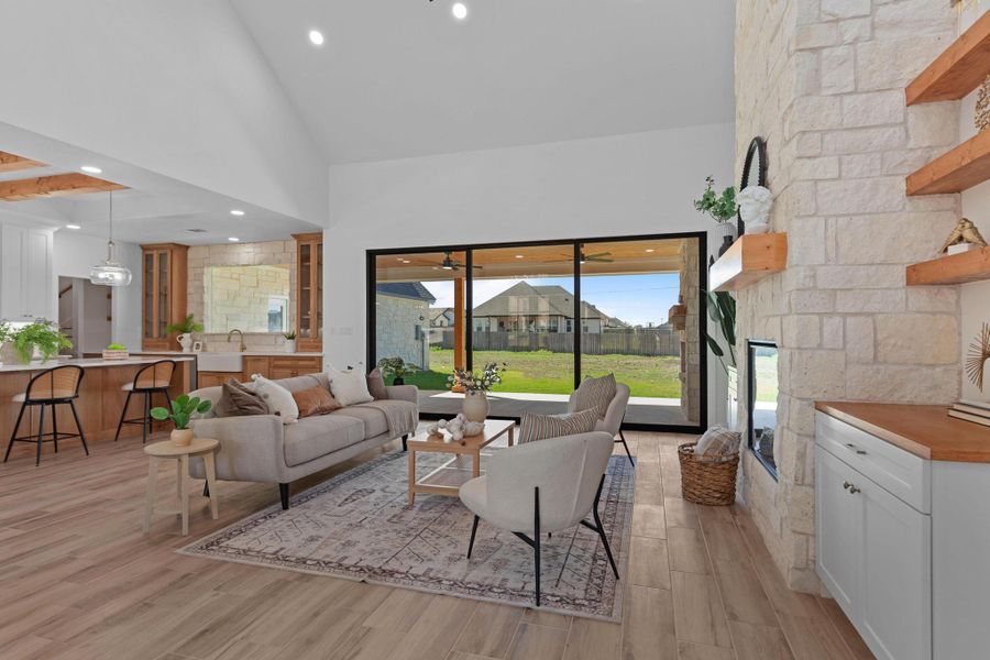 Living room with light wood finished floors, lofted ceiling, and recessed lighting Living room with light wood finished floors, lofted ceiling, and recessed lighting