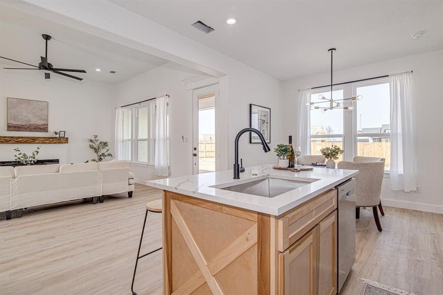 Kitchen featuring light brown cabinets, decorative light fixtures, healthy amount of natural light, light wood finished floors, and recessed lighting
