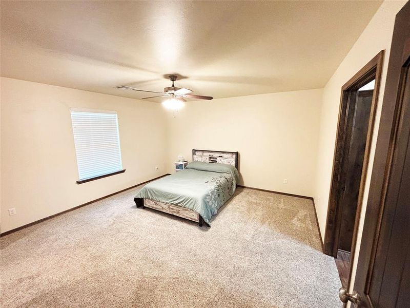 Carpeted bedroom featuring baseboards and a ceiling fan Carpeted bedroom featuring baseboards and a ceiling fan
