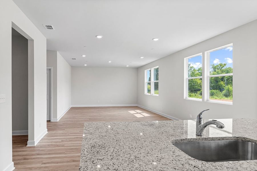 A large empty room with a sink and a large window.