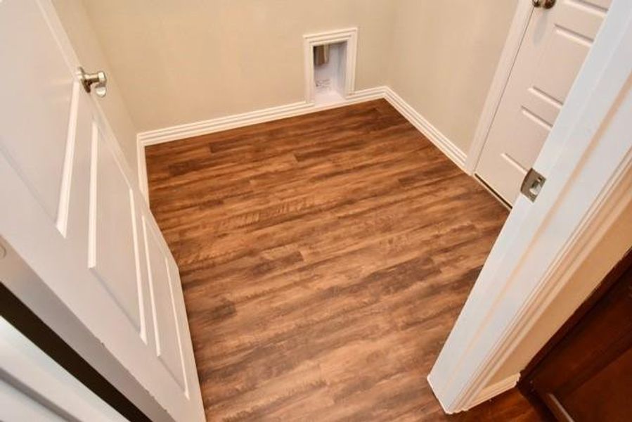 Laundry area with baseboards and dark wood-type flooring Laundry area with baseboards and dark wood-type flooring