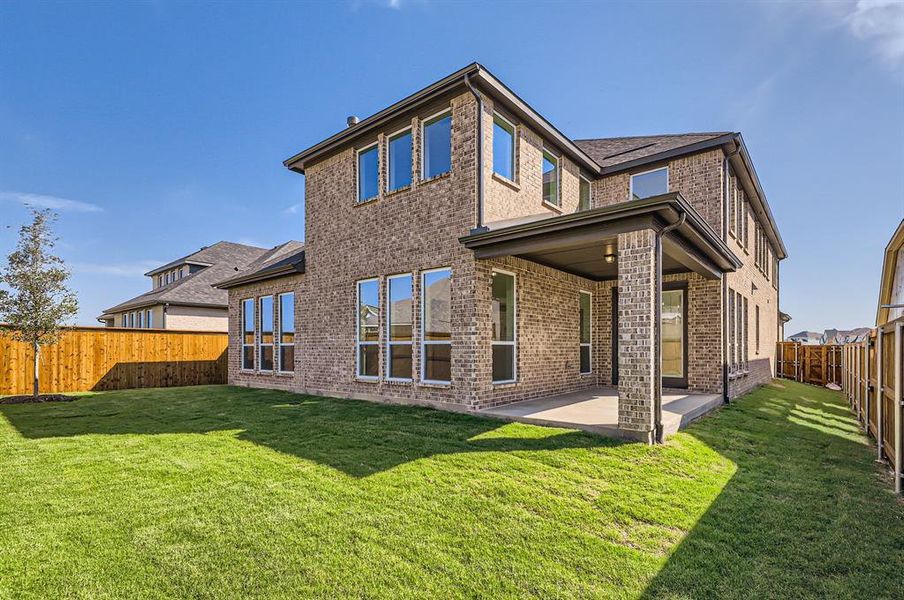 Rear view of property with a yard and a patio area