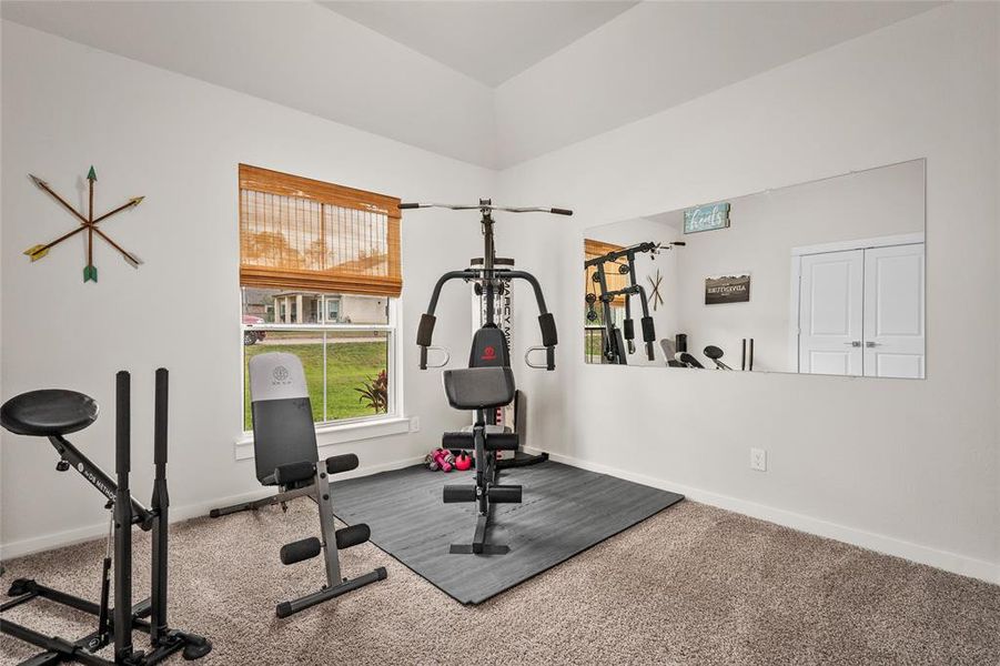 This is the first secondary bedroom and is at the front of the home. It is bright and currently used as a dedicated home gym space a large window with natural light.