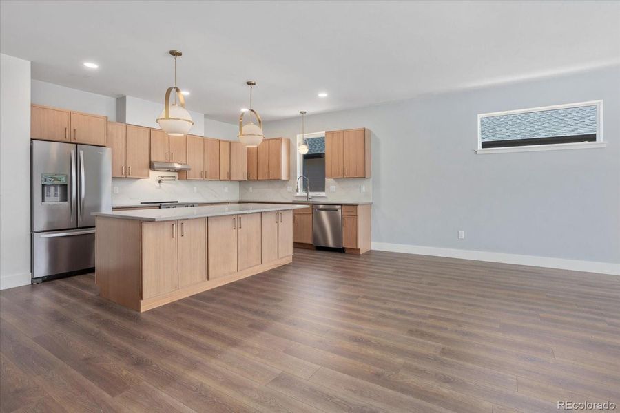 Kitchen boasts expansive island and manufactured quartz countertops