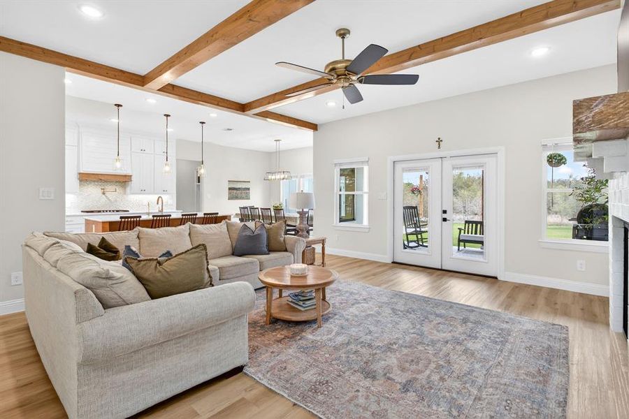 Living area with a ceiling fan, french doors, light wood-type flooring, beamed ceiling, and recessed lighting Living area with a ceiling fan, french doors, light wood-type flooring, beamed ceiling, and recessed lighting