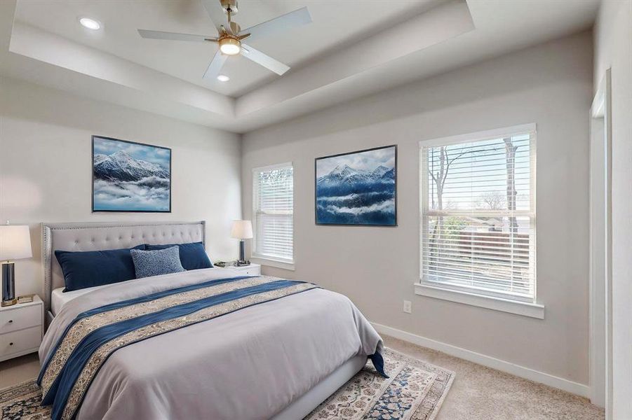 Virtual Staged Carpeted bedroom featuring a raised ceiling and ceiling fan