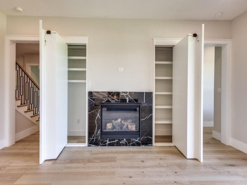 Living room built-in cabinets with doors open to access hidden storage