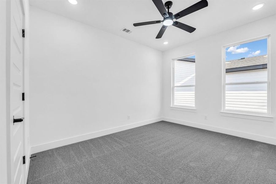 Spare room with dark colored carpet and plenty of natural light