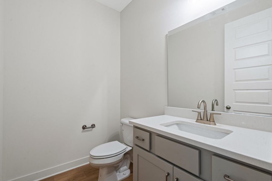 Vanity featuring a light gray cabinet base, an integrated rectangular sink, and a light-toned countertop Vanity featuring a light gray cabinet base, an integrated rectangular sink, and a light-toned countertop