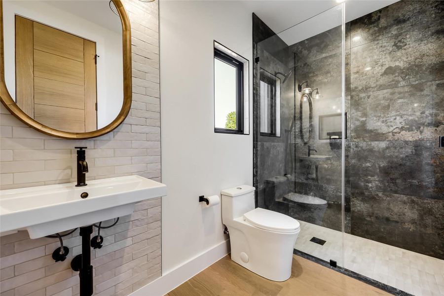 Full bathroom with wood finished floors, walk in shower, and tasteful backsplash