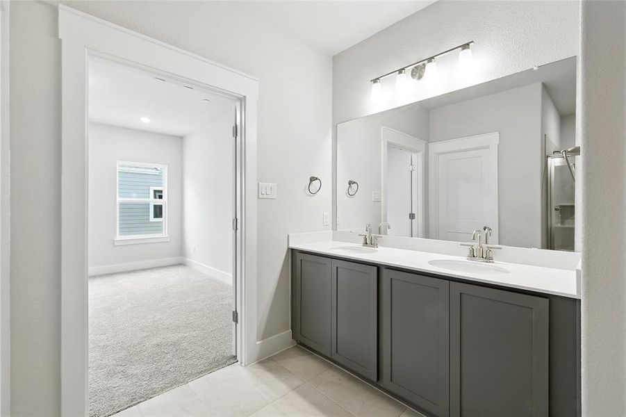 Full bathroom featuring double vanity and light tile patterned floors