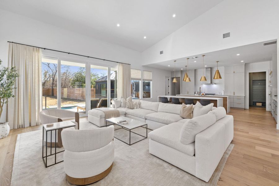 Living room featuring light wood-style floors, recessed lighting, and lofted ceiling