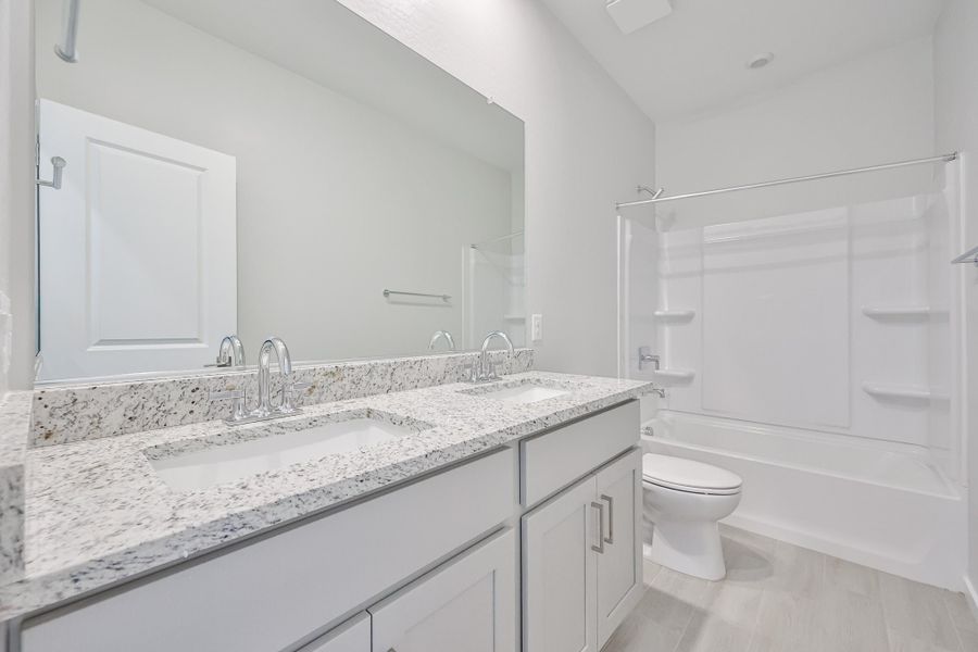 A bathroom with a sink toilet and shower. A bathroom with a sink toilet and shower.
