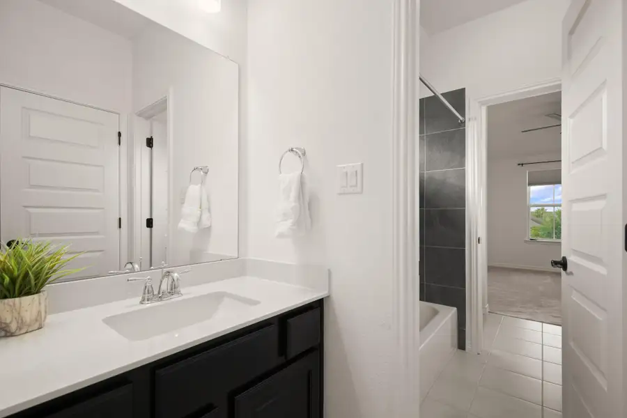 The full jack-n-jill bathroom connects to two of the secondary bedrooms, with private vanity areas for each room. The full jack-n-jill bathroom connects to two of the secondary bedrooms, with private vanity areas for each room.