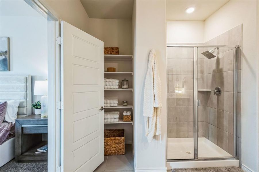 Bathroom with a shower with shower door and tile patterned floors