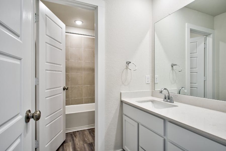A bathroom with a sink and a mirror.