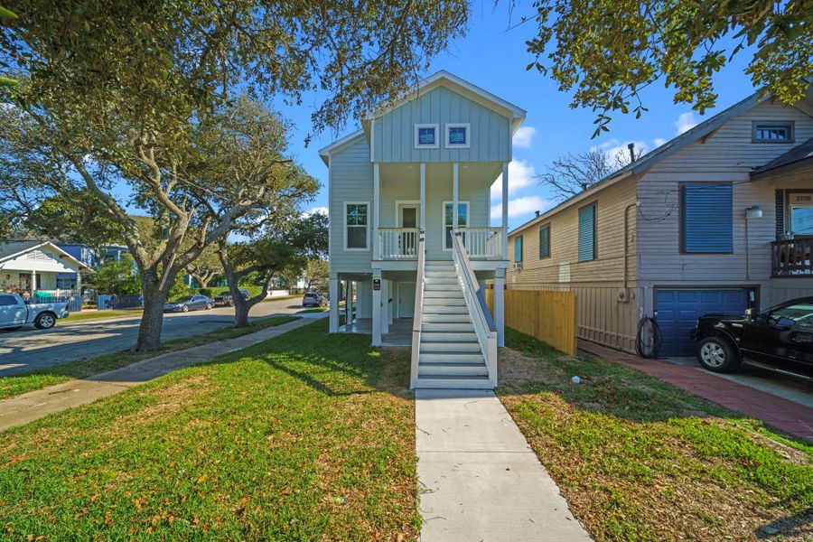 Charming elevated home with a welcoming front staircase, situated on a grassy lot with mature trees. The exterior features a modern design with a small balcony, offering curb appeal in a pleasant neighborhood setting. Charming elevated home with a welcoming front staircase, situated on a grassy lot with mature trees. The exterior features a modern design with a small balcony, offering curb appeal in a pleasant neighborhood setting.