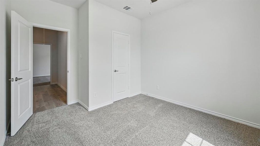 Unfurnished bedroom featuring light carpet and baseboards