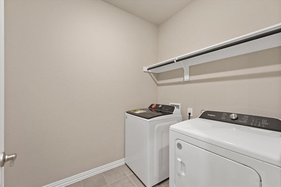 Laundry area featuring light tile patterned flooring and separate washer and dryer Laundry area featuring light tile patterned flooring and separate washer and dryer