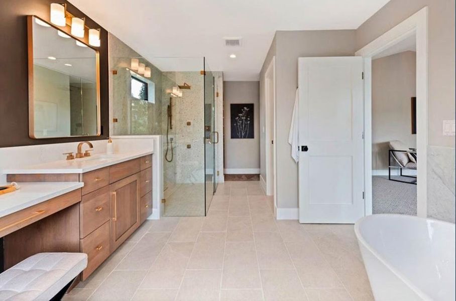 Full bath with vanity, a freestanding tub, a shower stall, and light tile patterned floors