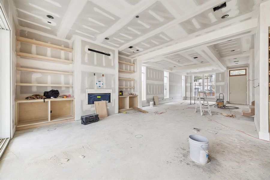 Family Room with Built-In Cabinetry and Floating Shelves.  There is a sleek direct vent fireplace.   Construction as of Jan. 13th, 2025.