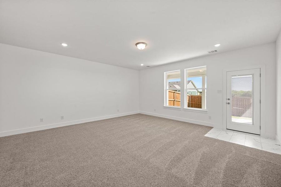 Living area with carpet flooring and lots of natural light