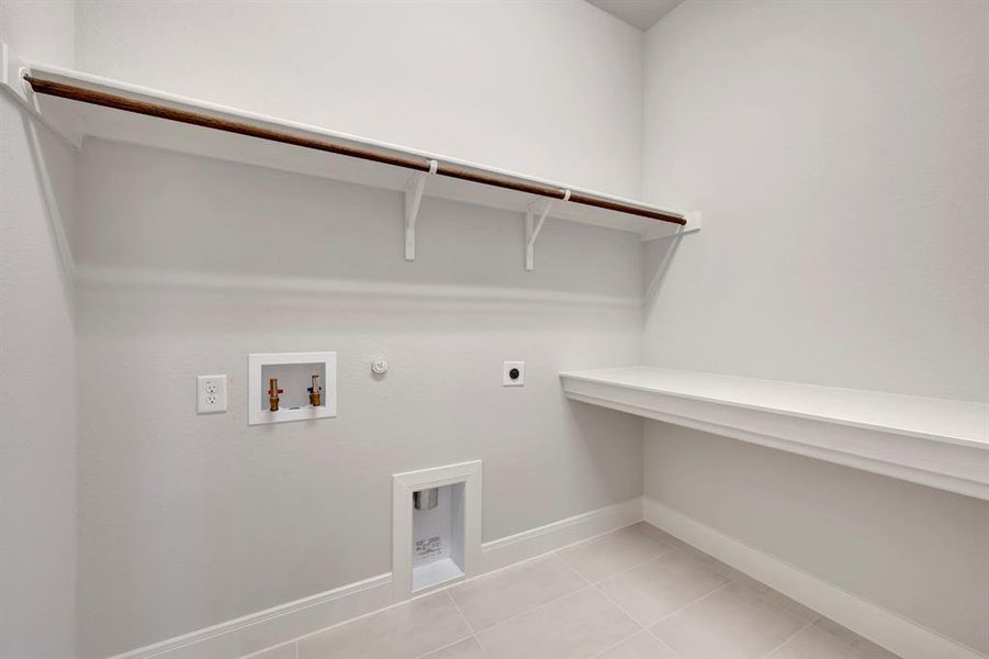 Laundry area with hookup for a gas dryer, electric dryer hookup, light tile patterned flooring, and washer hookup