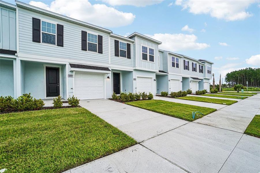 Front exterior of a new home in Twin Oaks, Zephyrhills, FL, highlighting curb appeal (Image 2). Front exterior of a new home in Twin Oaks, Zephyrhills, FL, highlighting curb appeal (Image 2).